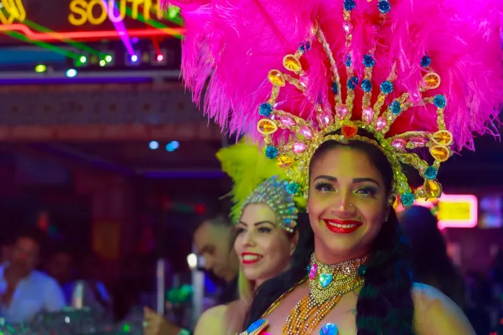 a person wearing a colorful hat standing in front of a store