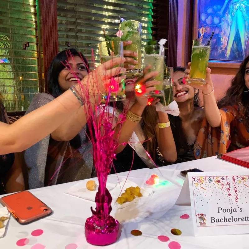 a group of people sitting at a table with a birthday cake