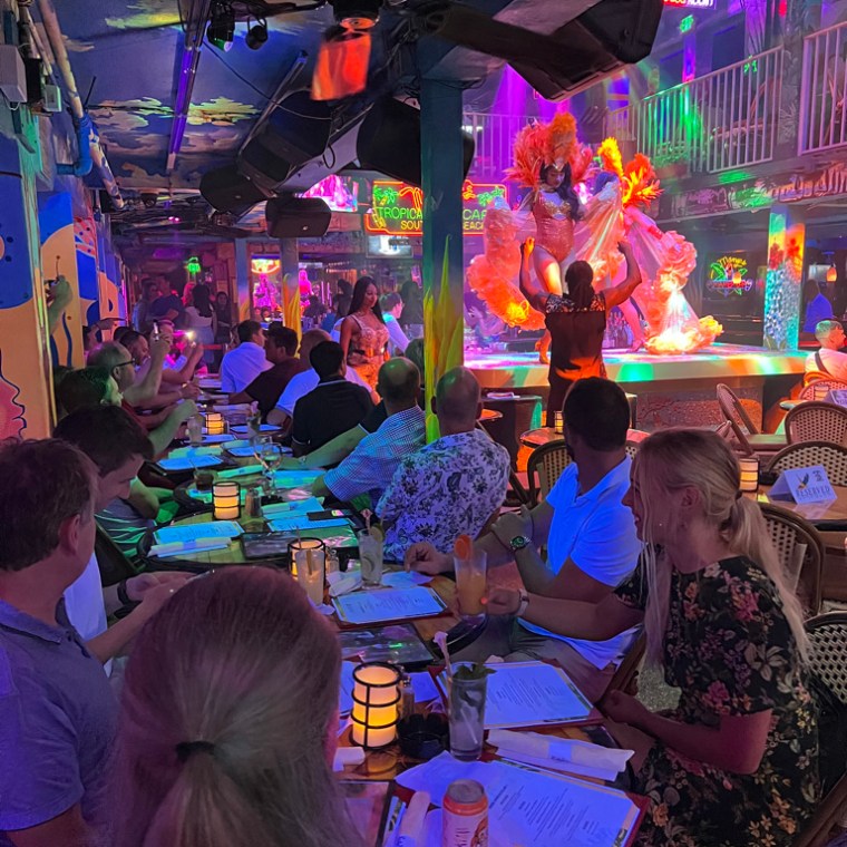 a group of people sitting at a table in front of a crowd