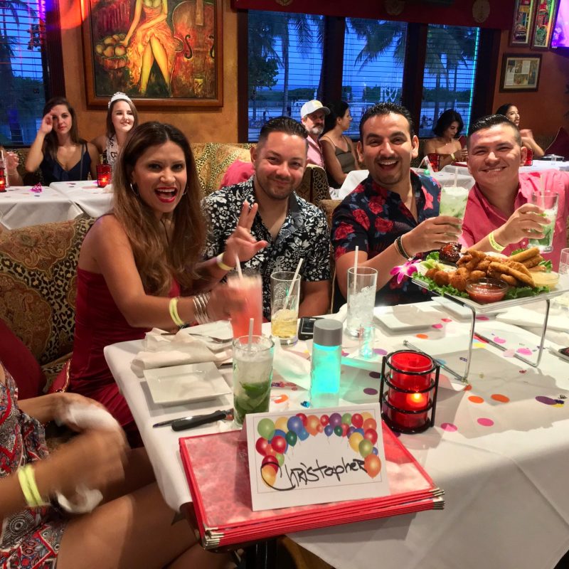 a group of people sitting at a table eating cake