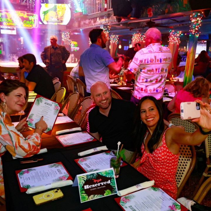 Malou Nubla et al. sitting at a table in front of a crowd