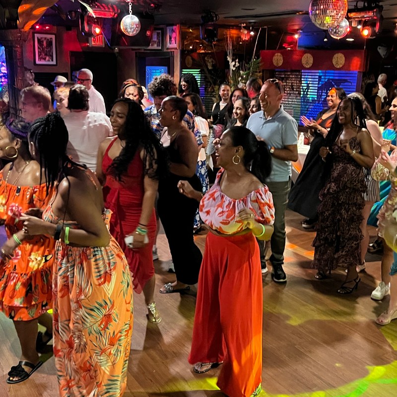 People dancing and smiling in a lively club atmosphere in Miami Beach taking salsa lessons and bachata classes from Salsa Mia www.salsamia.com
