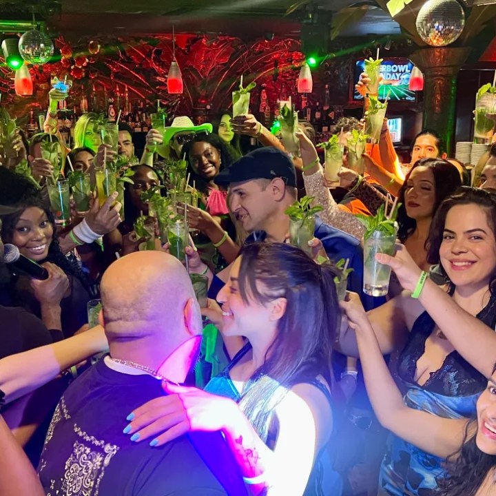 Visitors enjoying the Salsa Mia Miami Beach nightlife experience with cocktails, mojitos, music and dancing